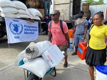 persone trasportano cibo del WFP con un carriola