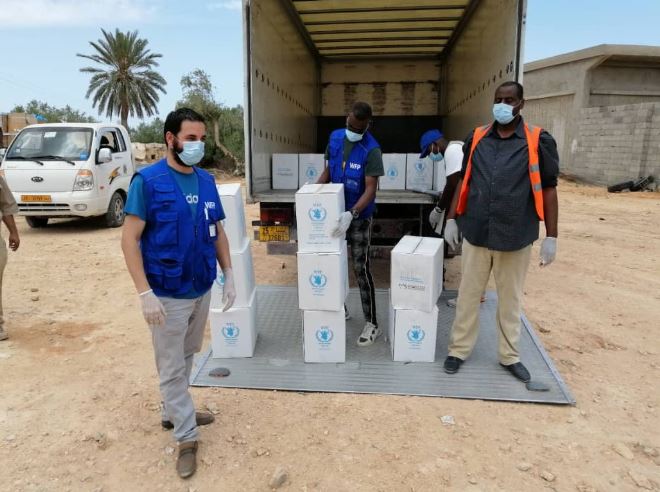 uomini scaricano scatole con assistenza alimentare WFP