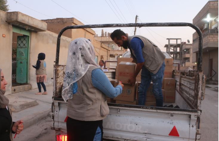 scatole di cibo scaricate da un furgone e consegnate a una sfollata siriana
