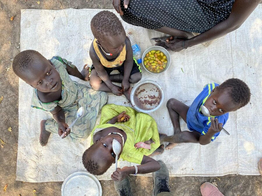 Sud Sudan: bambini a Akobo East, Jonglei, mangiano sorgo con dei frutti locali – l’ultima volta che la carestia è stata dichiarata nel paese era il 2017. 
