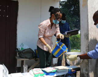 Louise Abayomi, Senior Research Fellow (Postharvest), Dipartimento Cibo e Mercati,  preparea il fufu mostrando al team congolese le corrette quantità degli ingredienti. Foto: WFP/Alice Rahmoun