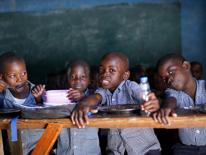 quattro bambini seduti a scuola 