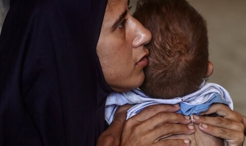 Woman holds infant in close-up