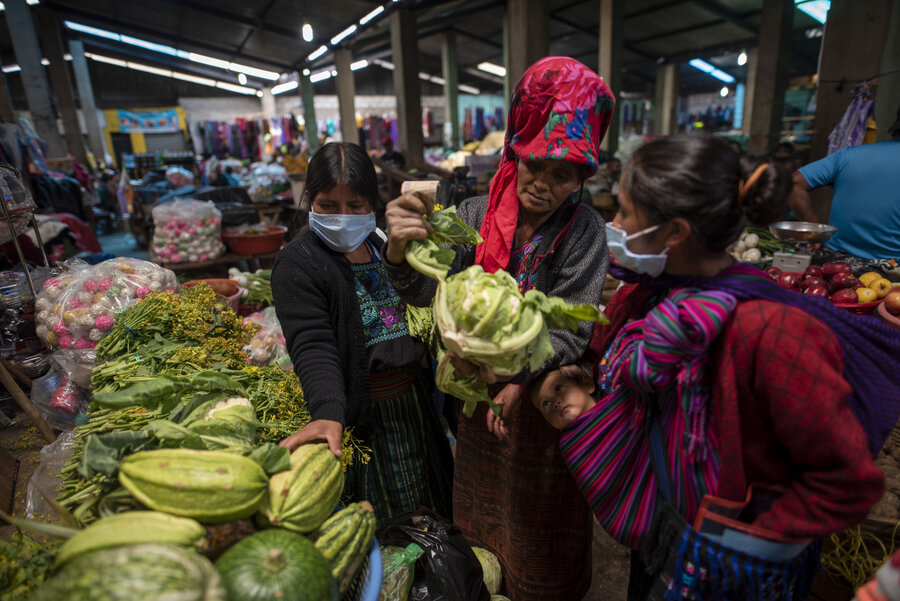 women shop in a market in Guatemala. 