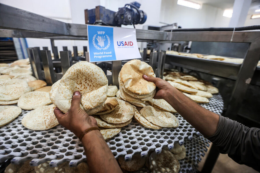 Hands hold bread cooked in bakery in Gaza