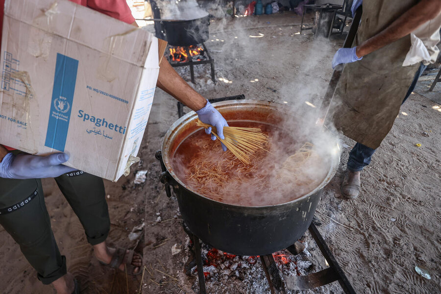 Spaghetti is take out of a WFP box and placed into a pot in a soup kitchen in Gaza