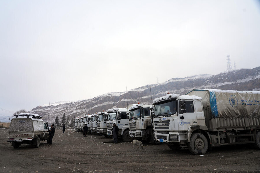A fleet of WFP trucks along a partially snowy hill range in Afghanistan