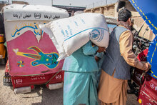 persone portano sacchi cibo WFP in spalla