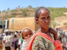 Madre etiope con figlia sulle spalle in un centro di distribuzione di cibo del WFP