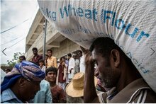Yemen. Un uomo con un sacco di farina di grano. 