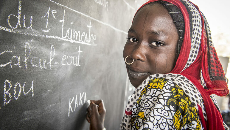 Kaka Marabou scrive il suo nome sulla lavagna della sua scuola a Yakoua, lago Ciad. Rifugiati, sfollati e altre comunità povere nel bacino del lago Ciad dipendono dall'assistenza umanitaria per la sopravvivenza. Anche l'accesso all'istruzione di base è limitato. WFP/Giulio d'Adamo