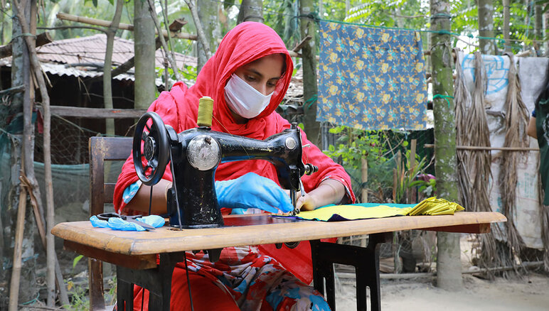 Durante la pandemia di Covid-19, a Cox's Bazar, in Bangladesh, il programma per i mezzi di sostentamento del WFP ha permesso alle donne della comunità ospitante e ai rifugiati Rohingya di realizzare mascherine poi distribuite dal governo locale e dalle agenzie umanitarie, dando così la possibilità di ricevere uno stipendio mensile, formazione professionale commerciabile e alfabetizzazione finanziaria in aggiunta a una borsa di studio per avviare un'impresa. WFP/Nalifa Mehelin