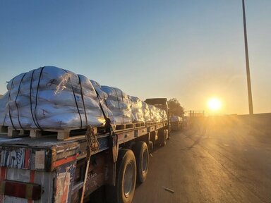 Camion del WFP in fila al tramonto