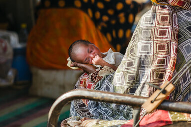 La neonata Hinda tra le braccia della madre nel campo profughi di Kassala. Foto: WFP/Abubakar Garelnabei